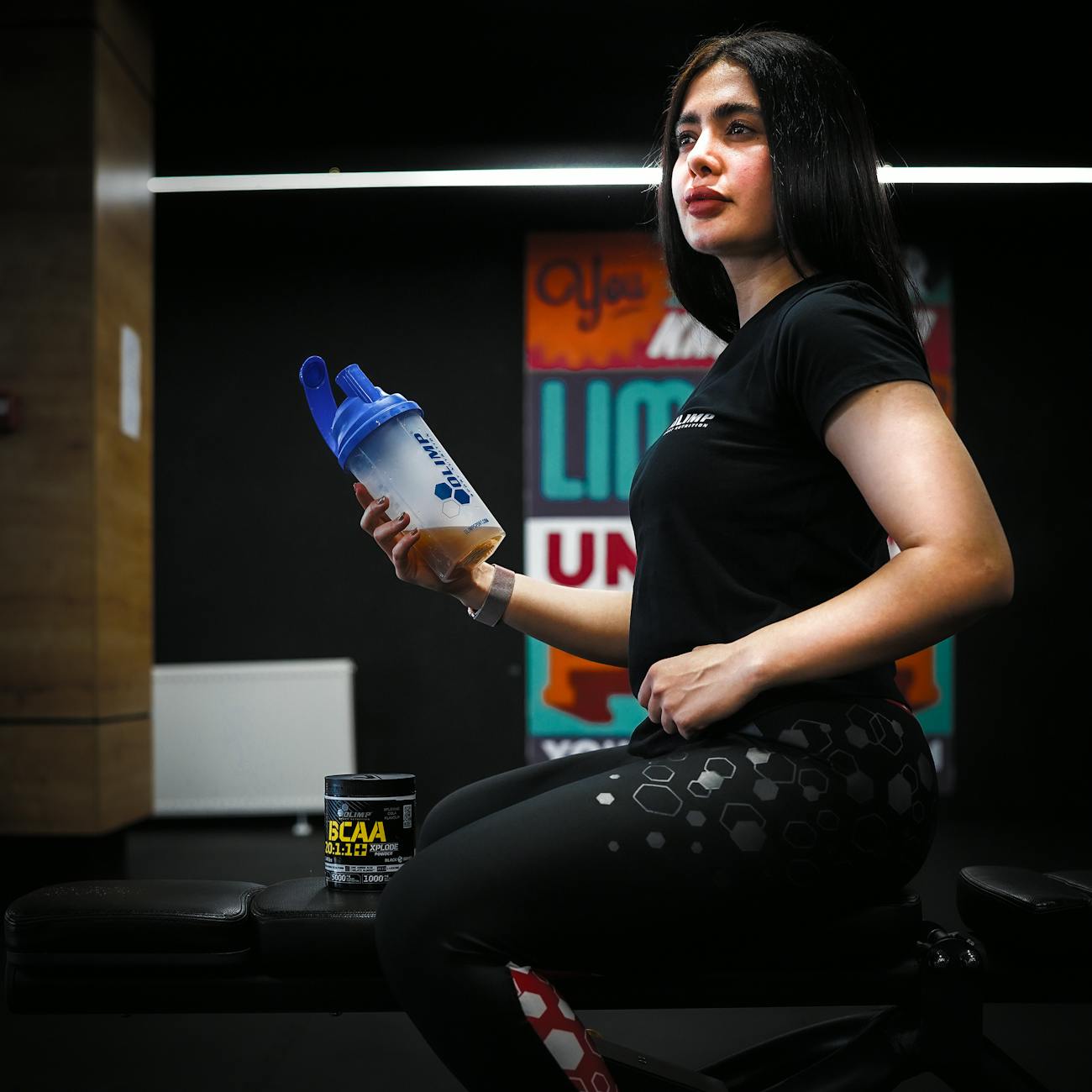 woman sitting on bench at gym