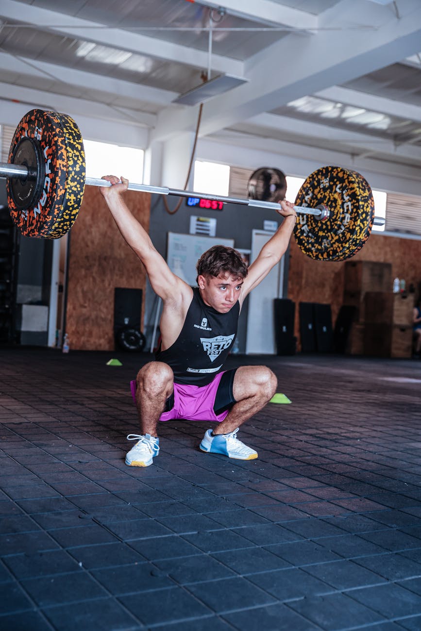 man performing overhead weightlifting in gym