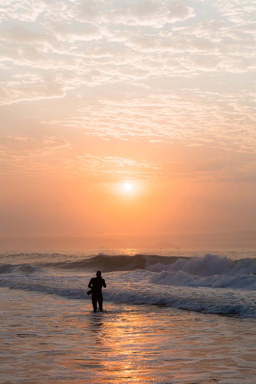 silhouette of person at sunrise on ocean shore