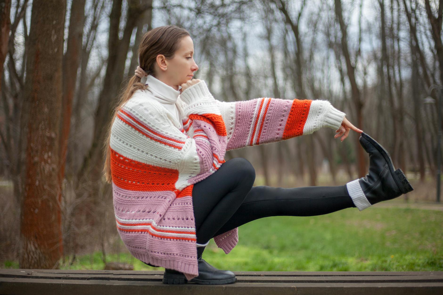 woman balancing outdoors in knit sweater