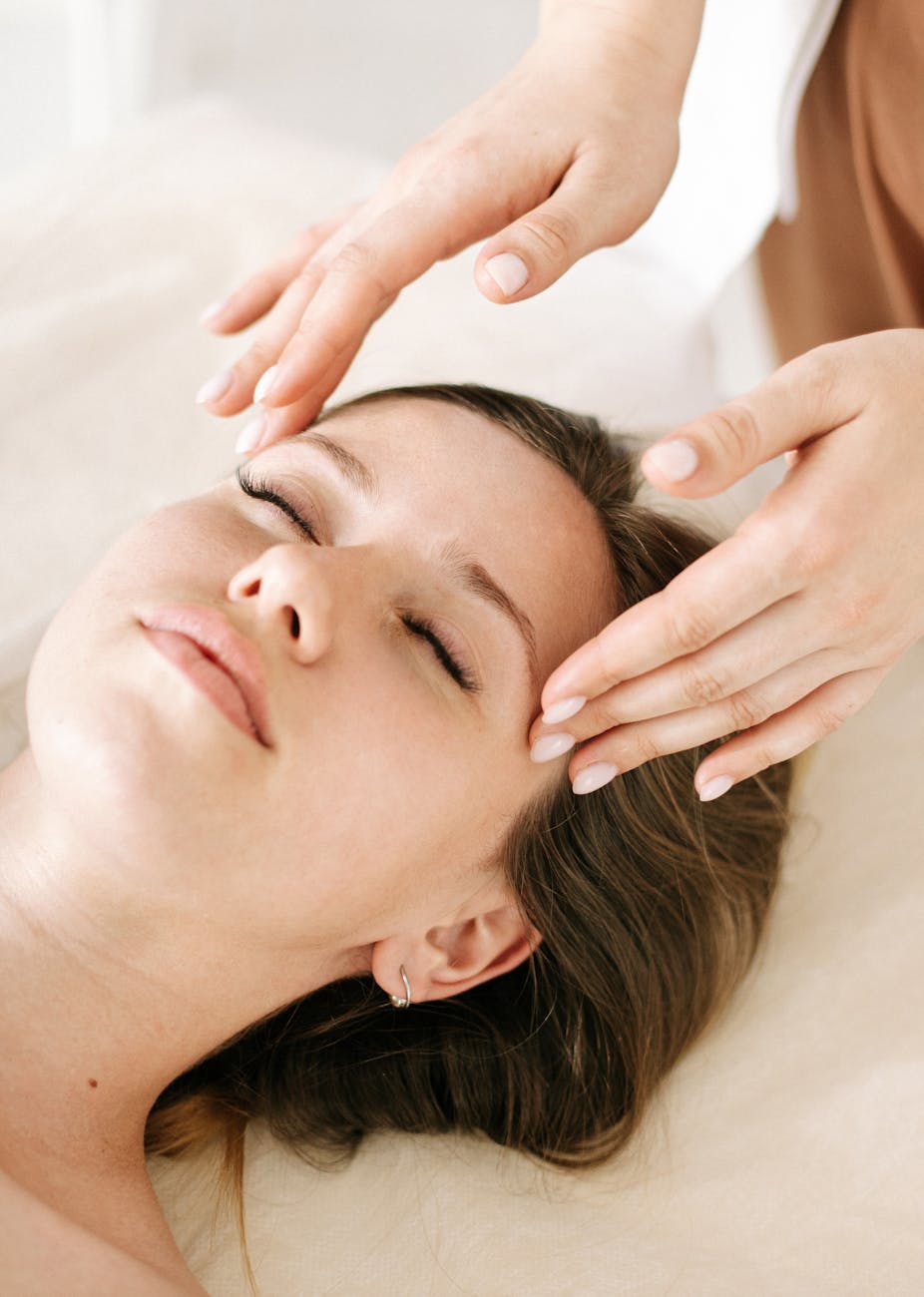 a woman eyes closed having a head massage