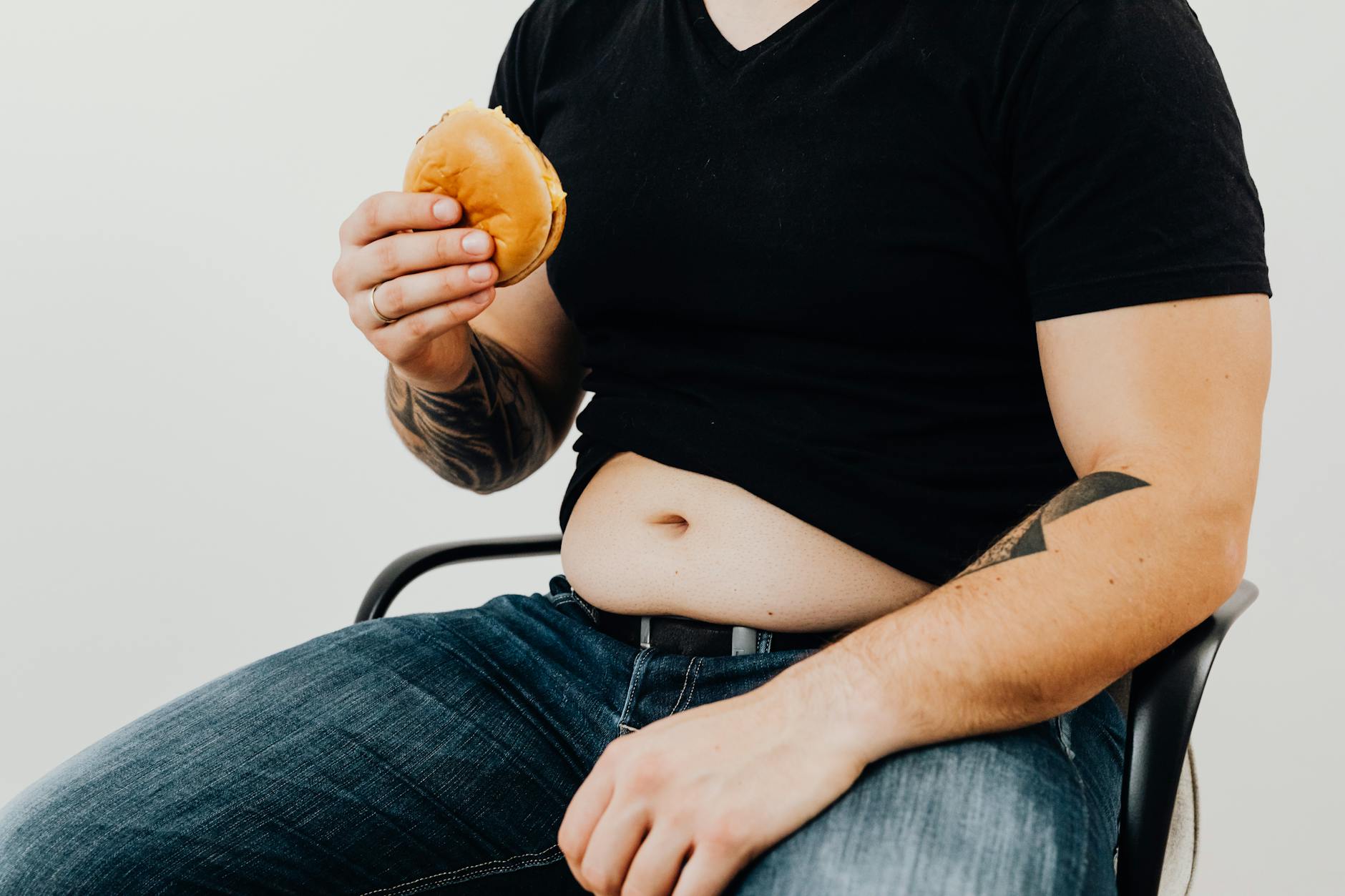 a man in black shirt holding a hamburger