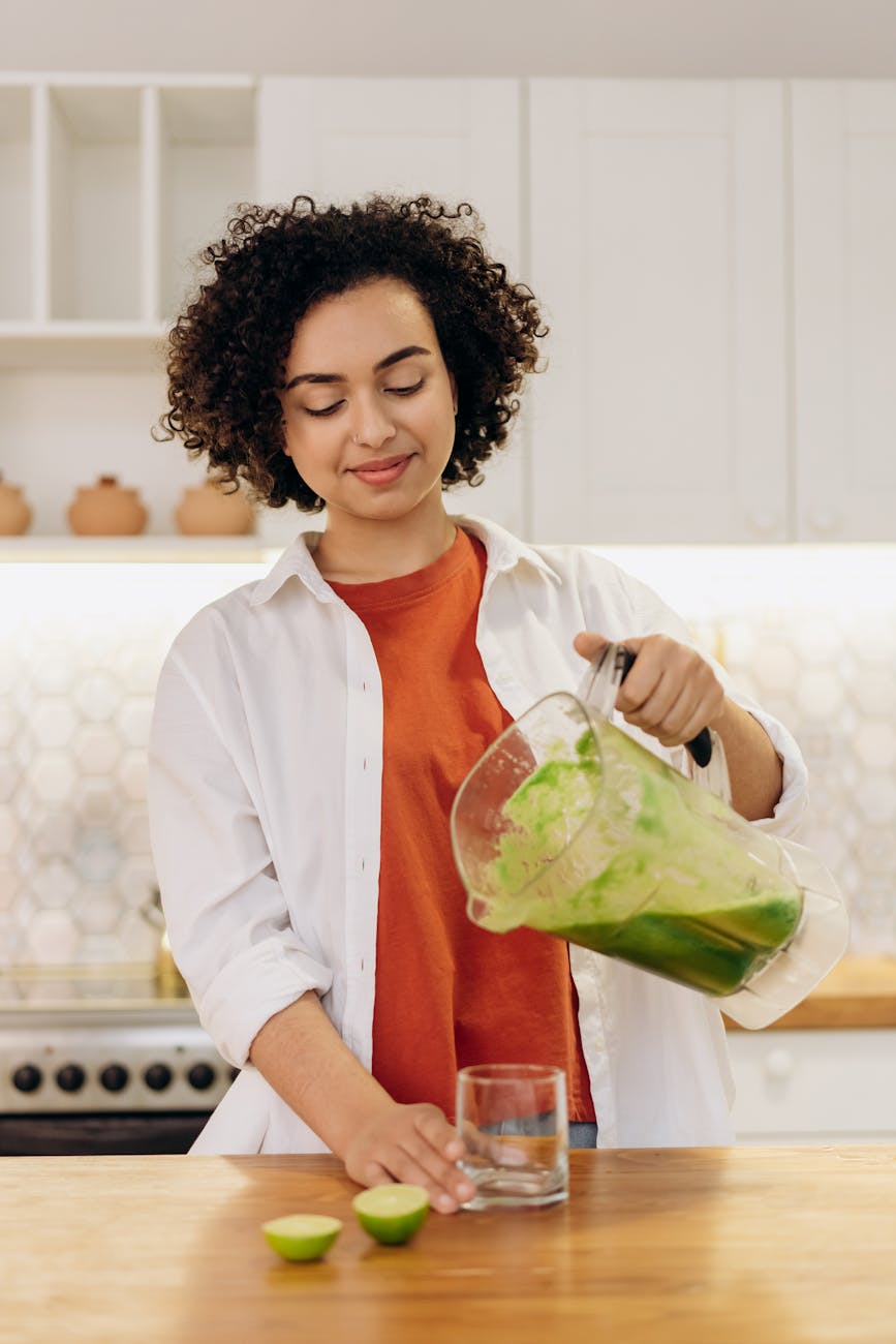 woman pouring fruit smoothie on glass