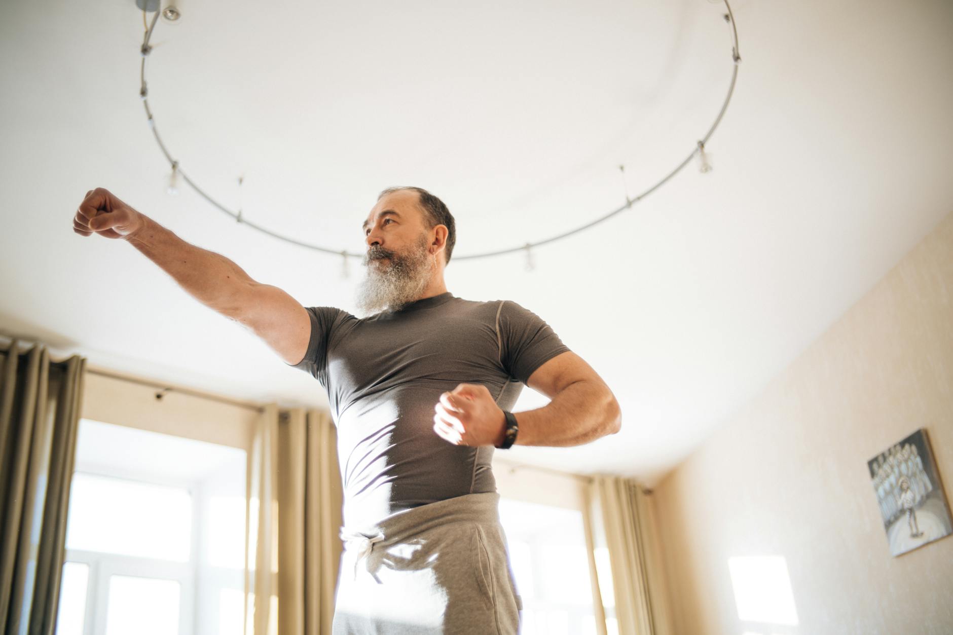 a low angle shot of an elderly man in gray shirt with beard on his face