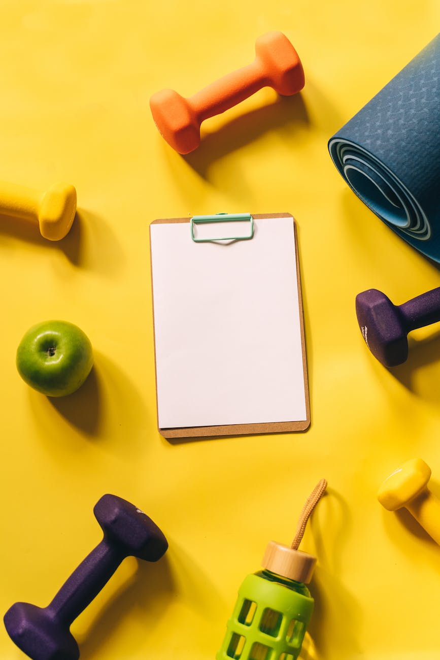 dumbbells beside a clipboard
