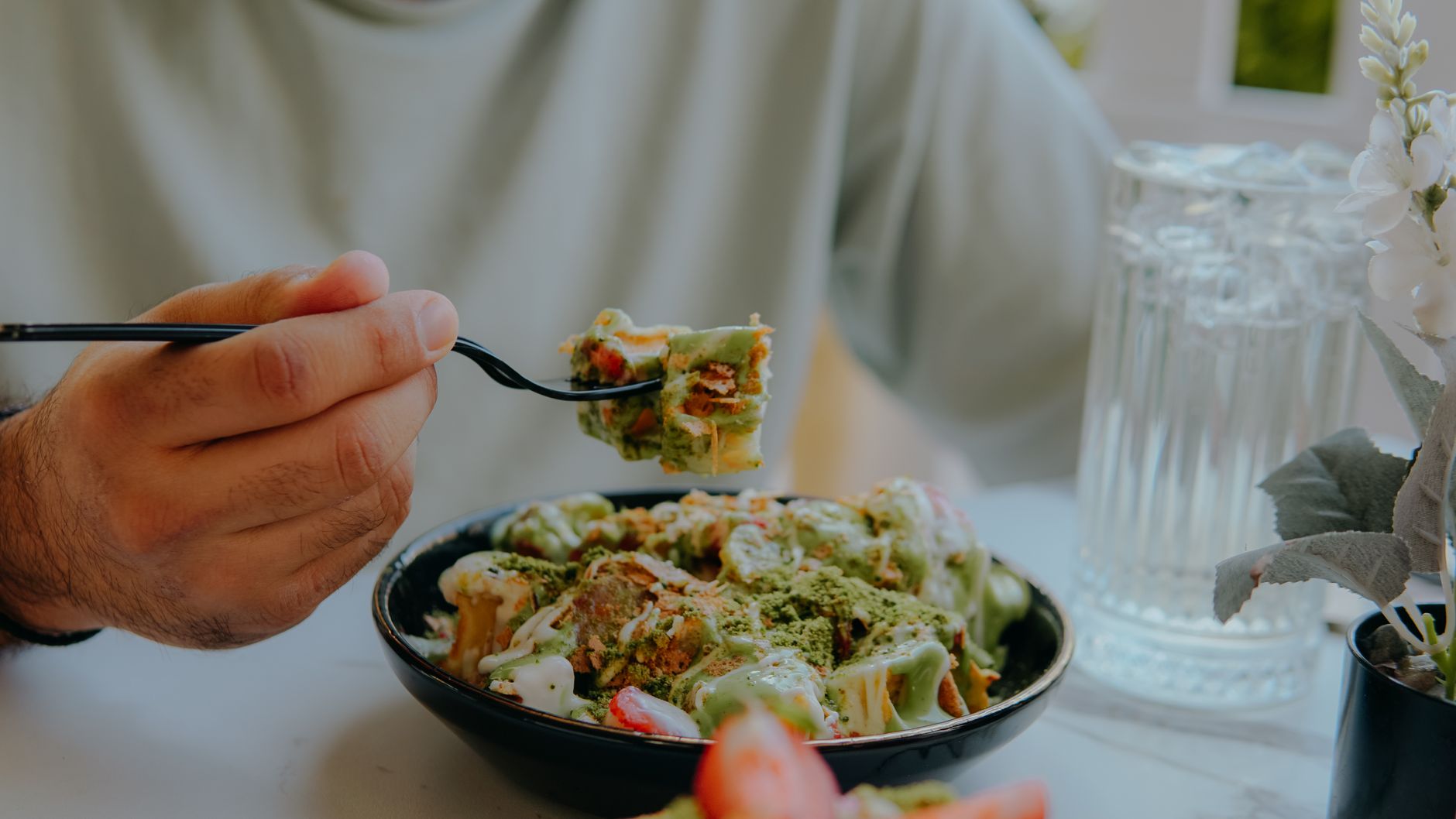 person enjoying delicious pasta with green sauce