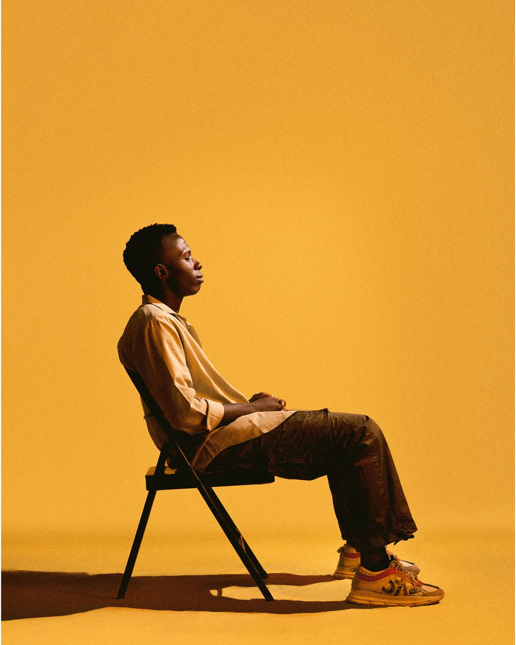 profile of person sitting on chair in yellow setting