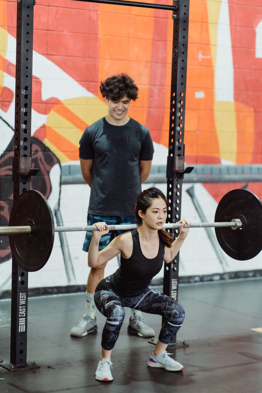 a woman lifting a barbell with plates