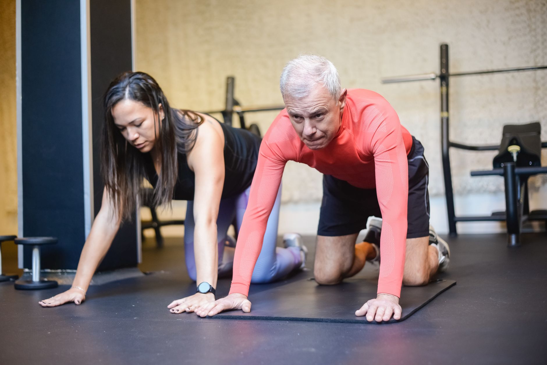 a personal trainer teaching an elderly man to exercise